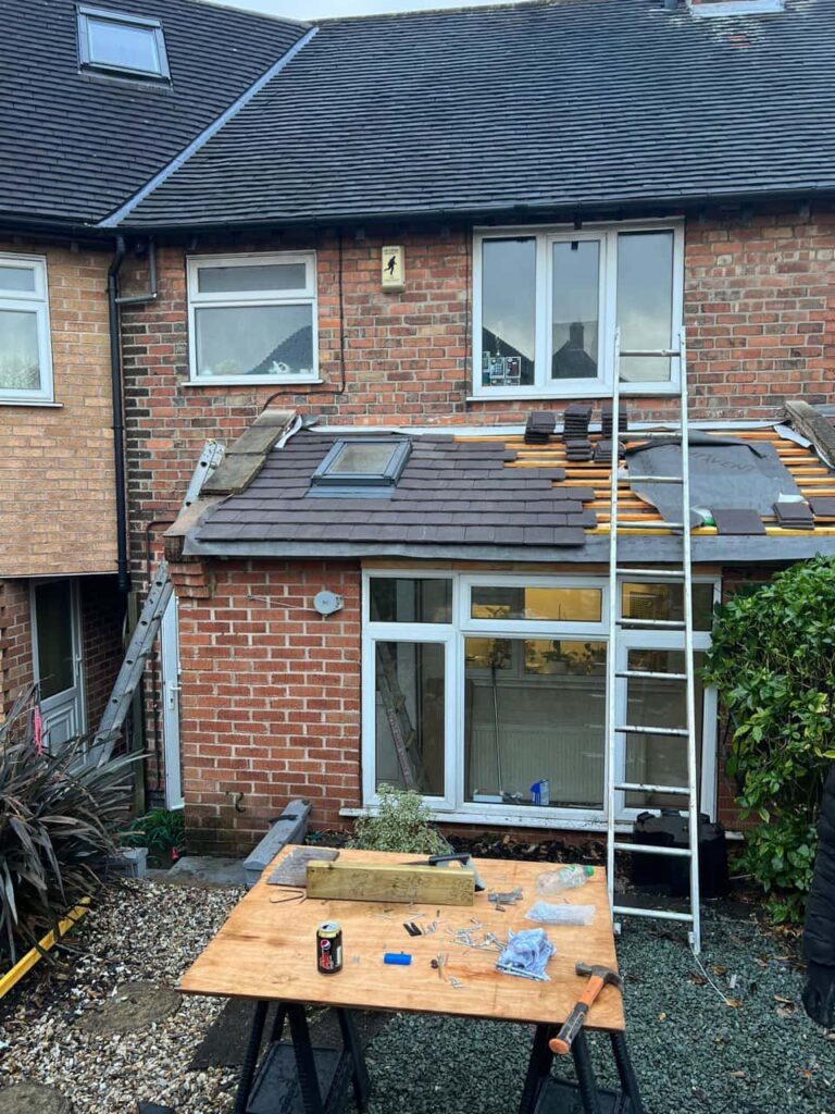 This is a photo of a roof extension that is having new roof tiles installed. This is a photo taken from the roof ridge looking down a tiled pitched roof on to a flat roof. Works carried out by Broughton Astley Roofing Repairs