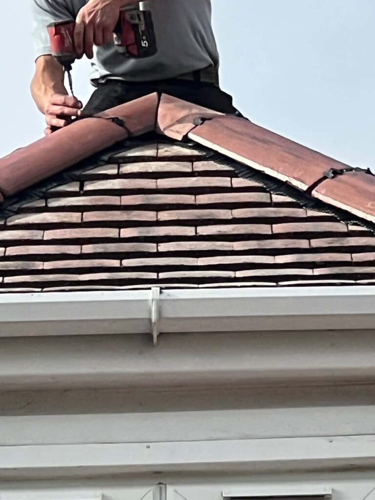 This is a photo of one of the operatives of Broughton Astley Roofing Repairs installing new ridge tiles